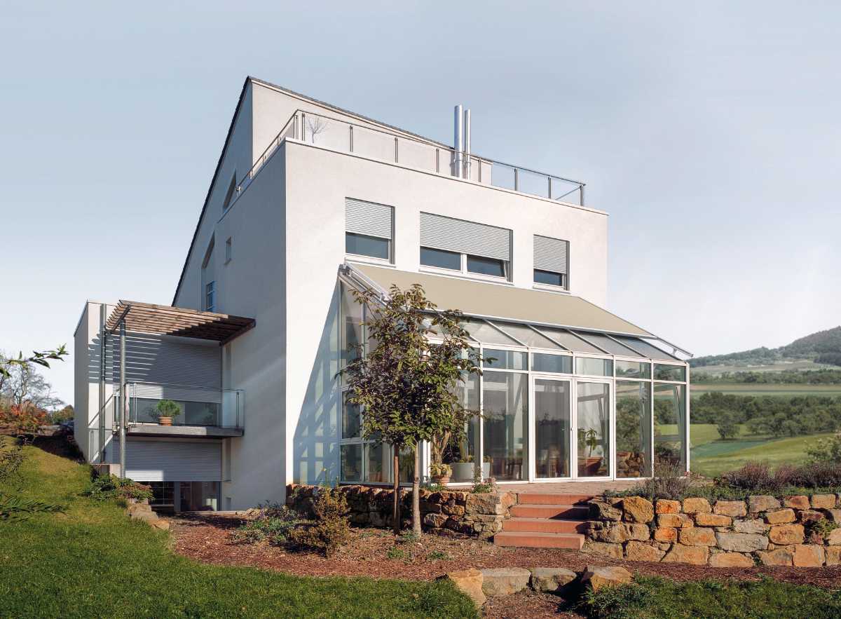 Modernes Einfamilienhaus mit Wintergarten und Gartenlandschaft