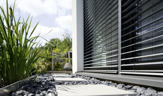 Moderne Jalousien an einem Haus mit Garten